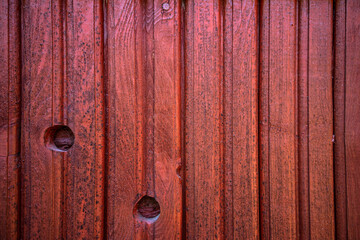 The texture of a wooden clapboard painted with red rowan color paint