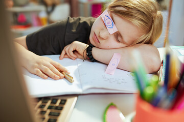 tired modern child in grey shirt sleeping at home in sunny day - obrazy, fototapety, plakaty