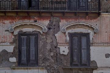 old abandoned building with broken windows and cracks in the wall