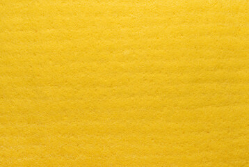Textile. Background from yellow material. Enlarged spongy fibers. Sponge texture. Close up