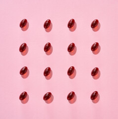 Pattern made of krill oil softgels on a pink background - source of omega 3