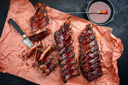 Barbecue pork spare loin ribs St Louis cut with hot honey chili marinade served as top view on butcher paper