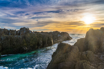 Sunset through the rocks across the Atlantic Ocean