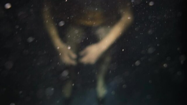Woman floats inert in the dark