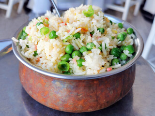 Peas Pulao or Matar Pulao in a copper bowl. One pot rice dish.  Fried rice with green peas. Traditional Indian food.