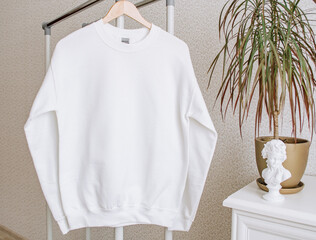 White sweatshirt mockup on a hanger. Blank hoodie mockup with leaves.
