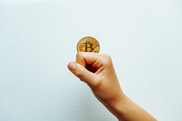 Bitcoin in hand on a white background.
