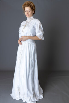 An Edwardian woman wearing a white lace trimmed blouse and skirt