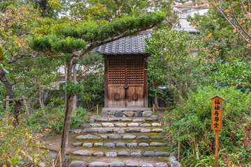 Small shrine with the Japanese name of longevity god Fukurokuju god on a wooden board in the Mukojima-Hyakkaen Gardens dedicated to the seven lucky gods pilgrimage.
