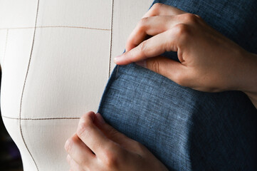 Fitting blue clothes on a mannequin. TAiloring and designing concept.Dressmaker. Fitting clothes on a dummy