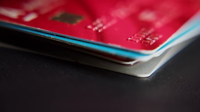 A man puts bank cards in a pile, stacks of used credit cards are laid out on the table close-up footage.