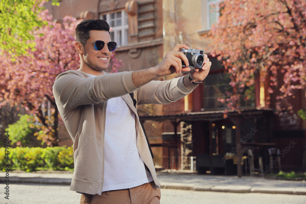 Sticker happy male tourist with camera on city street