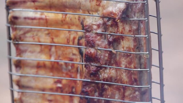 Carne assada no fogo no ch&atilde;o e na lenha.
