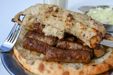 Cevapi or cevapcici. Traditional meat dish in Balkans. Meat prepared on barbecue and served with bread somun and onions. Popular food. 