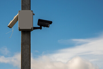 Security camera on a pole. Cloudy sky in the background