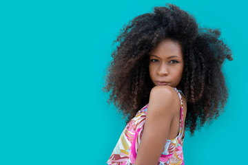 beautiful young woman posing on an aquamarine blue background