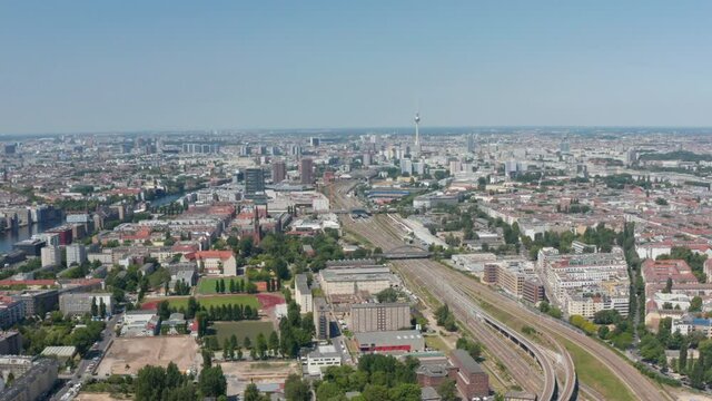 Aerial view of main railway track leading through large city. Fernsehturm TV tower in distance. Berlin, Germany
