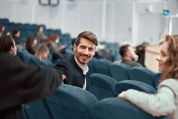 young man sitting in the lecture hall of the business center.
