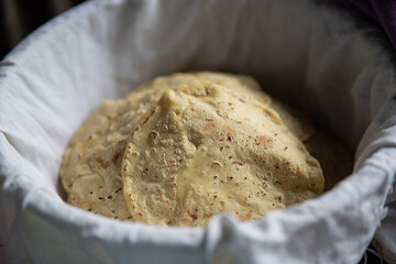 Corn tortillas in a basket with a tablecloth to cover them