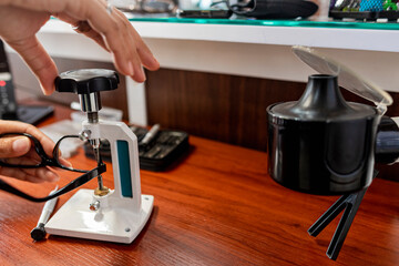 Manos de una mujer reparando lentes con diferentes herramientas 