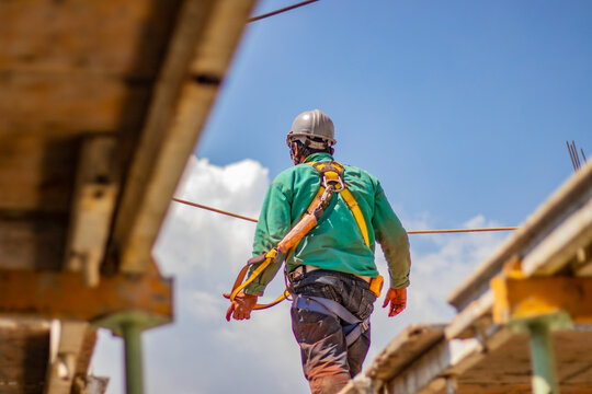 Trabajador con implementos de seguridad en lo alto de la construcción de un edificio