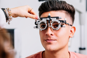 Primer plano de un Joven hombre con unas gafas de medición para realizar exámenes de la vista por...