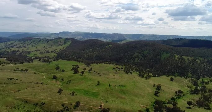 Wide hovering over green pastures and hill ranges in Sofala NSW as 4k.
