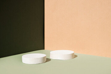 Abstract minimal scene with geometrical forms. Cylinder podiums on green and beige background. Abstract background. Scene to show cosmetic podructs. Showcase, display case. 3d render.