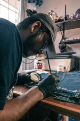 young latin artist paints a denim piece