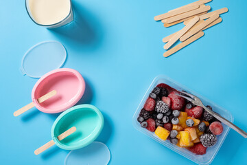 preparing milk popsicle with various fruit slices