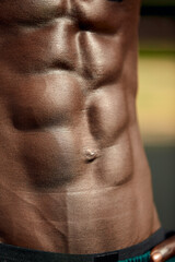 Male muscular belly, close-up, black man's abdominal relief.