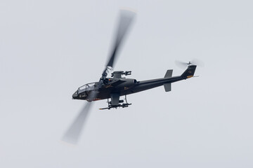 The shape of an AH-1 Cobra attack helicopter (in Vietnam war color scheme, with shark teeth) ...