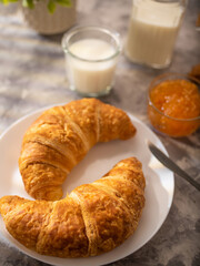 Croissants, milk and orange jam. Tasty breakfast. White background. Low angle view. Close-up. Hotel and restaurant business. Cafe, diner, home cooking. Book of recipes.