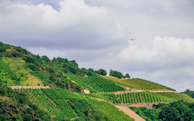 Fototapeta na wymiar fields of crops on a mountain while an airplane irrigates them