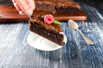 slice of chocolate cake with raspberries on cake spatula