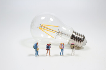 a mini hikers standing see the vintage light bulb. Travel Concept