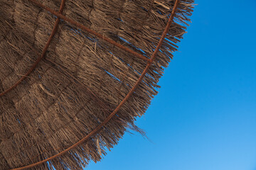 Straw umbrellas and sunbeds on the beach of Illetes in Formentera, Spain.