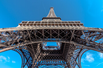 bottom perspective view of the eiffel tower with blue sky in the background
