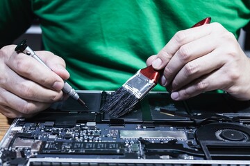 Man fixing laptop computer - technology computer reparing concept