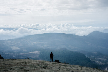 man walks in a meadow with a mountain background
