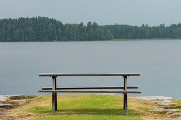 Hofsnas, Sweden A lone picnic table on the side of a lake.