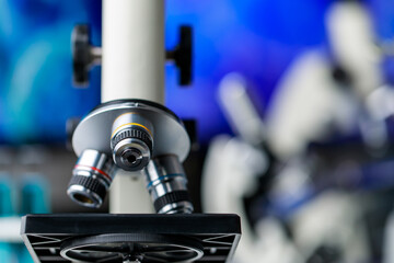 Naklejka premium High technology scientific microscope with lens objectives for efficient magnification to observe or diagnose microorganisms or pathogenic bacteria in biology research or chemistry lab.