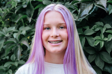 Smiling teen girl wearing dental braces, cute caucasian girl with pink hair wearing orthodontic...