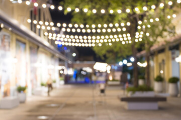 abstract blur image of night festival with a street walk and led light on tree bokeh for background