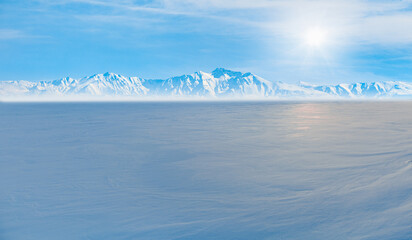 Frozen lake with snowy mountain range in the background - Cildir Lake in Kars Province to Turkey