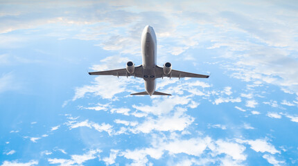 Naklejka premium White passenger airplane under the amazing clouds - Travel by air transport
