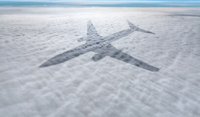 Shadow of an airplane flying above the clouds
