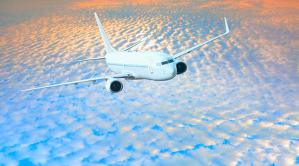 White passenger airplane under the amazing clouds  - Travel by air transport