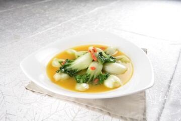 stir fried small cabbage with Chinese herbal in yellow chicken stock soup in white background asian halal vegan menu