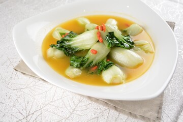 stir fried small cabbage with Chinese herbal in yellow chicken stock soup in white background asian halal vegan menu